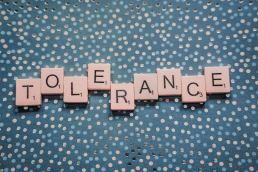 Tolerance spelled out in letter tiles on green polka dot background