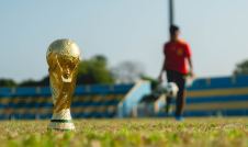 World Cup Trophy on soccer field with player in the background