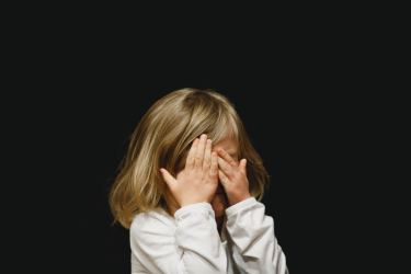 Young girl covering her eyes with her hands