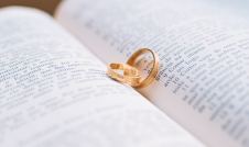 Gold wedding rings on open Bible