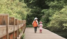 Mother and daughter walking on a bridge