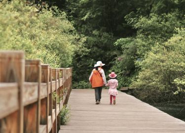 Mother and daughter walking on a bridge