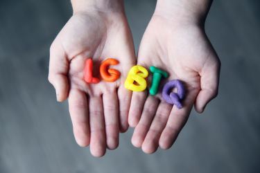 Hands holding LGBTQ Letters