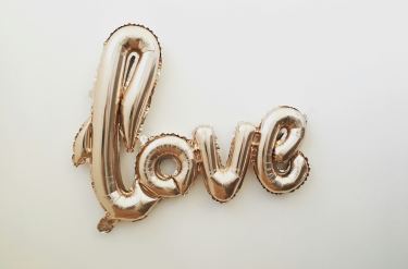 gold balloon spelling love on a white background